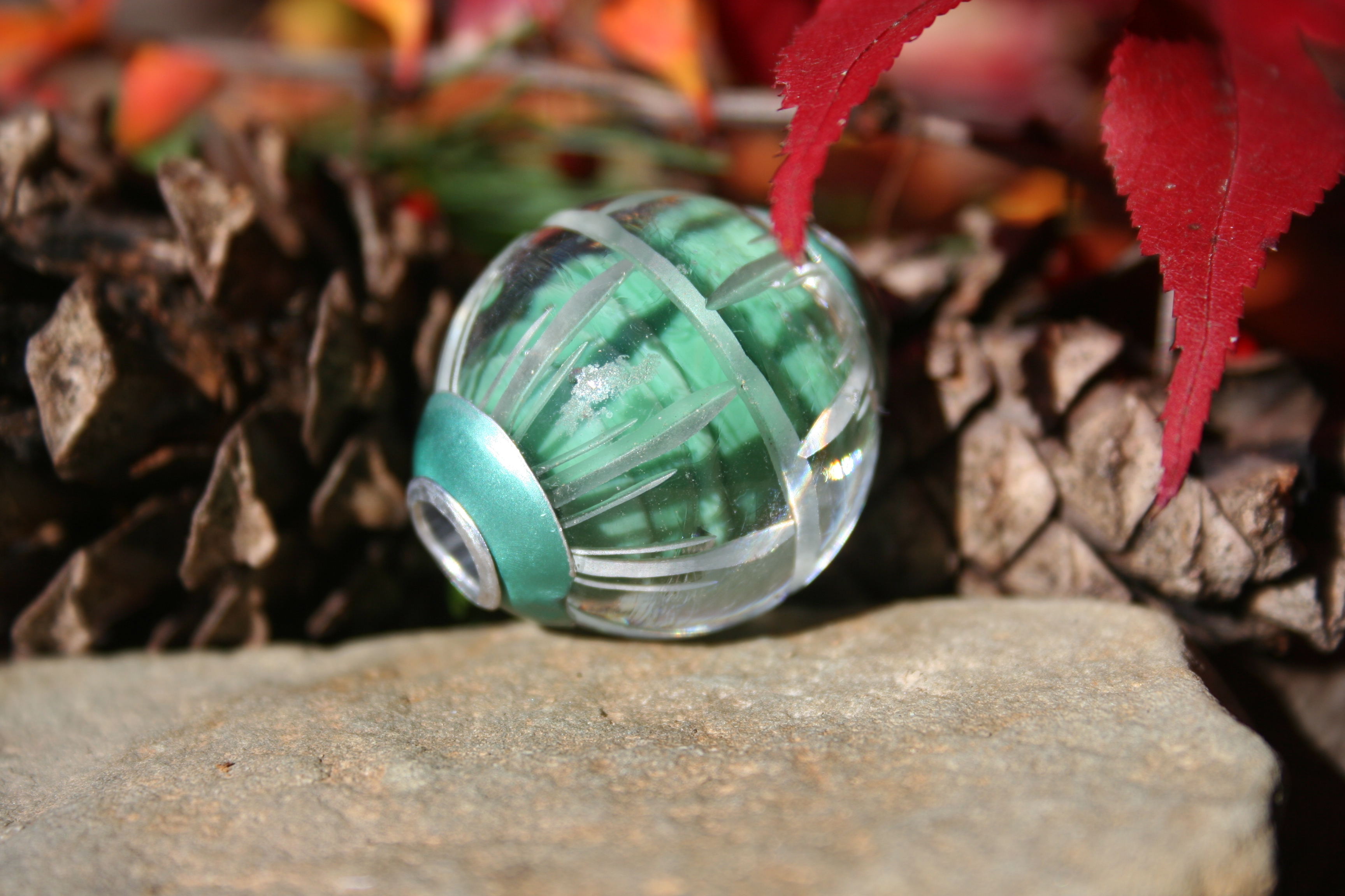 glass bead- green carved and capped